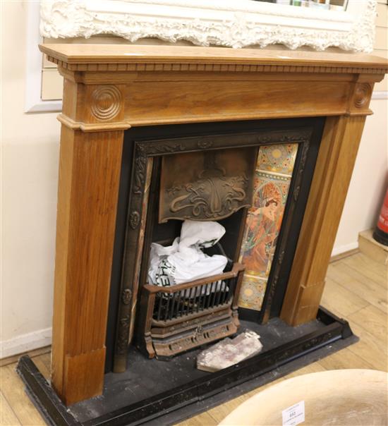 A tiled fire place and fire surround, W.137cm